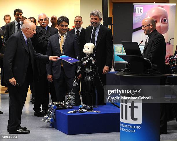 Italian President Giorgio Napolitano receives a book from the robot 'iCub' during the visit at IIT Italian Institute of Technology on May 4, 2010 in...