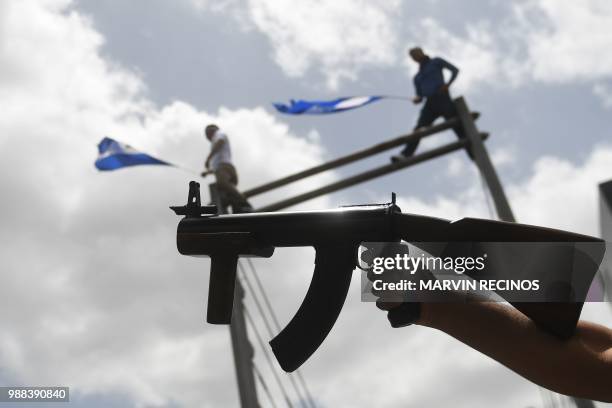 An armed protester takes part in the "Marcha de las Flores" -in honor of the children killed during protests- in Managua on June 30, 2018. - At least...