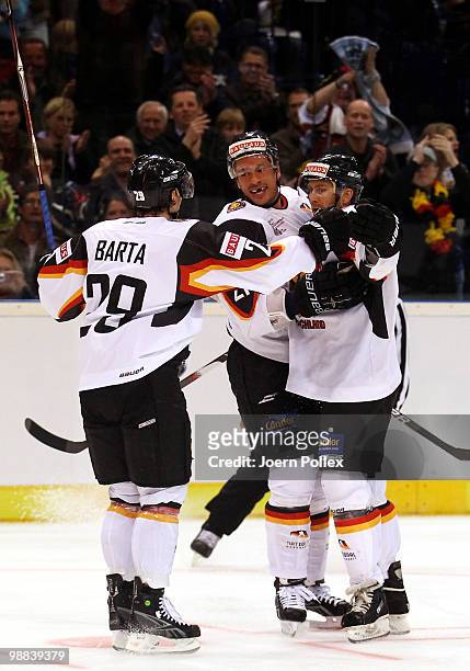 Sven Felski of Germany celebrates with his team mates Alexander Barta and John Tripp after scoring his team's first goal during the pre IIHF World...