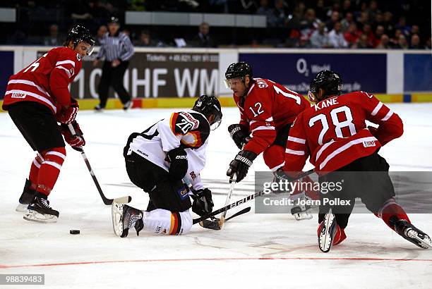 Kris Russsell , Ryan Smyth and Evander Kane of Canada challenge Robert Dietrich of Germany during the pre IIHF World Championship match between...