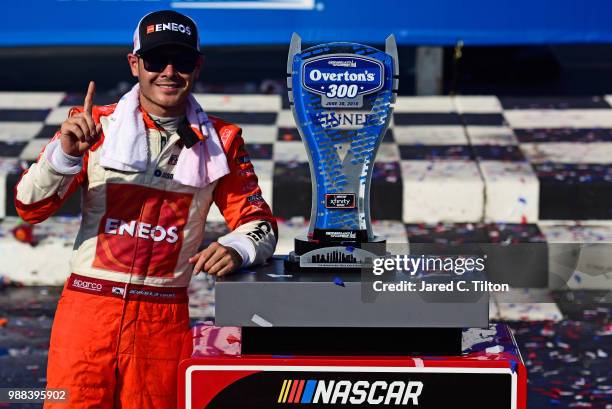 Kyle Larson, driver of the ENEOS Chevrolet, poses with the trophy in Victory Lane after winning the NASCAR Xfinity Series Overton's 300 at...