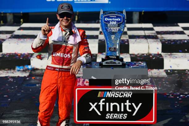 Kyle Larson, driver of the ENEOS Chevrolet, poses with the trophy in Victory Lane after winning the NASCAR Xfinity Series Overton's 300 at...