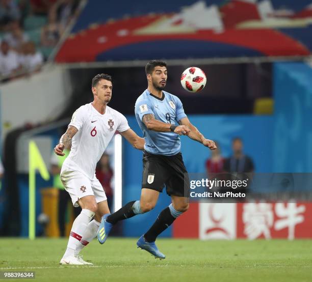 Portugal's Jose Fonte, left, and Uruguays Luis Suarez struggle for a ball during the 2018 FIFA World Cup Russia Round of 16 match between Uruguay and...