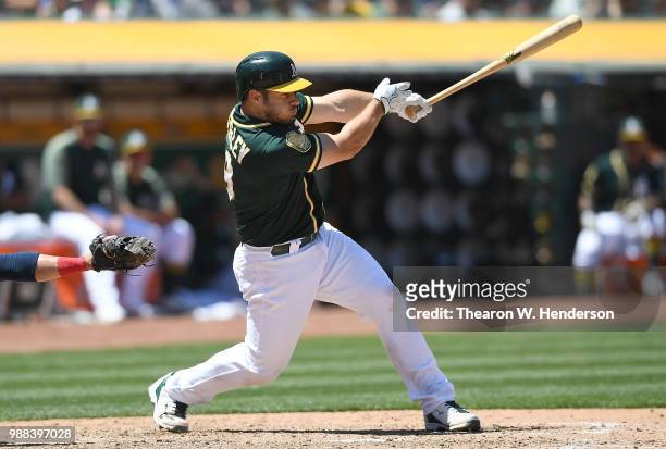 Josh Phegley of the Oakland Athletics hits a two-run home run against the Cleveland Indians in the bottom of the six inning at Oakland Alameda...