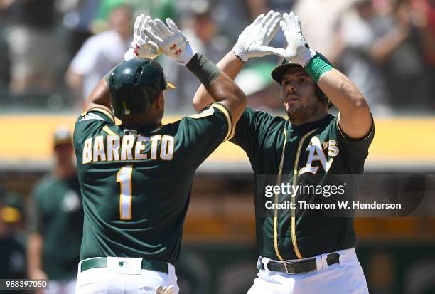Josh Phegley and Franklin Barreto of the Oakland Athletics celebrates after Phegley hit a two-run home against the Cleveland Indians in the bottom of...