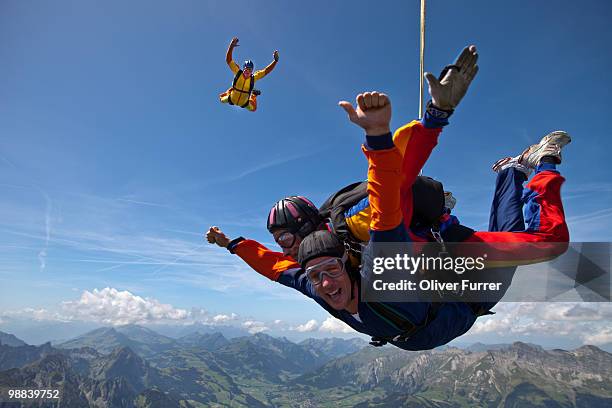 tandem couple having fun in the sky together. - saanen stock pictures, royalty-free photos & images