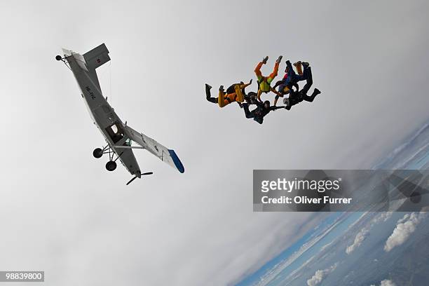 formation divers holding together after exit plane - saanen stock pictures, royalty-free photos & images