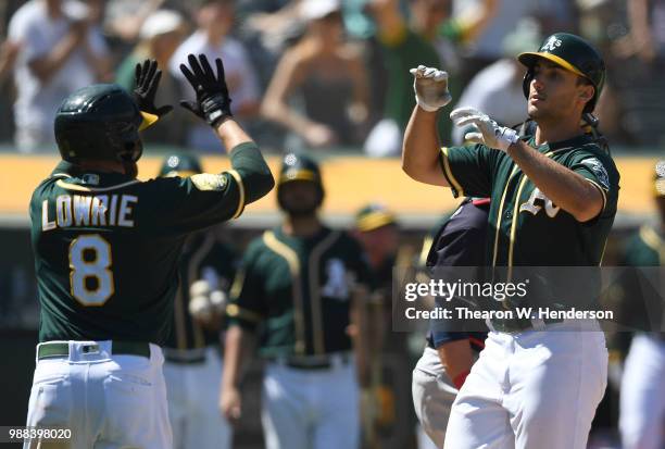 Matt Olson and Jed Lowrie of the Oakland Athletics celebrates after Olson hit a two-run home run against the Cleveland Indians in the bottom of the...