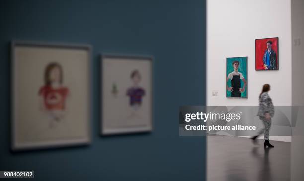 Museum assistant walks past different paintings during a press preview of the exhibition 'Patrick Angus. Private Show' at the Kunstmuseum in...