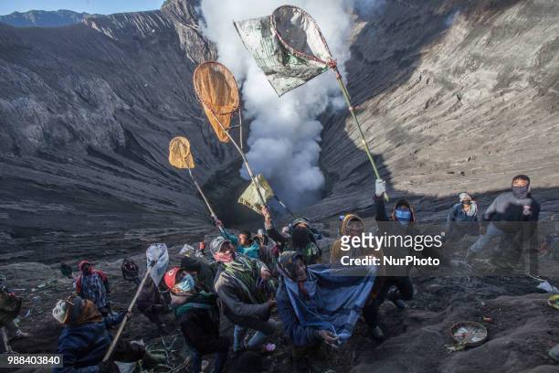 Villagers try to catch Tenggerese sacrifation that thrown to the volcano during Yadnya Kasada Festival at Mount Bromo, Probolinggo, East Java, on...