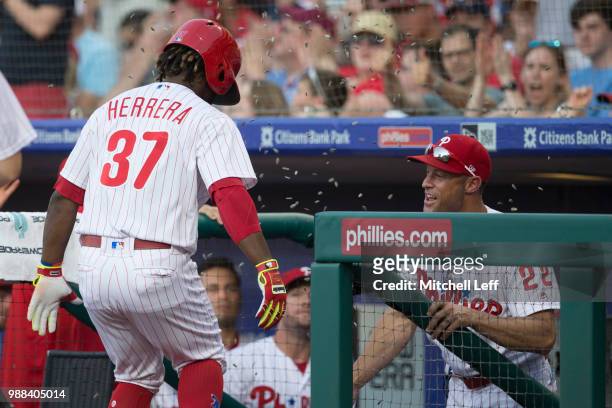 Odubel Herrera of the Philadelphia Phillies celebrates with manager Gabe Kapler after hitting a solo home run in the bottom of the third inning...