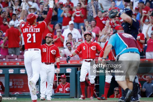 Billy Hamilton and Tucker Barnhart of the Cincinnati Reds react after a grand slam home run by Michael Lorenzen in the seventh inning against the...