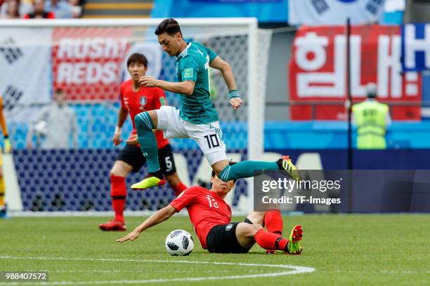 Jachoel Koo of Korea Republic and Mesut Oezil of Germany battle for the ball during the 2018 FIFA World Cup Russia group F match between Korea...