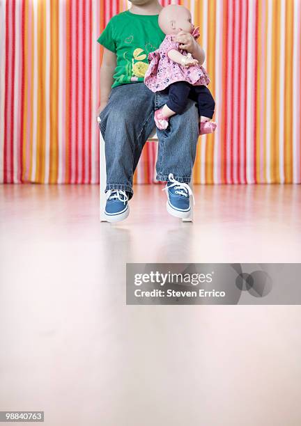 Young Girl Sitting In Chair With Doll On Lap, Foto de stock