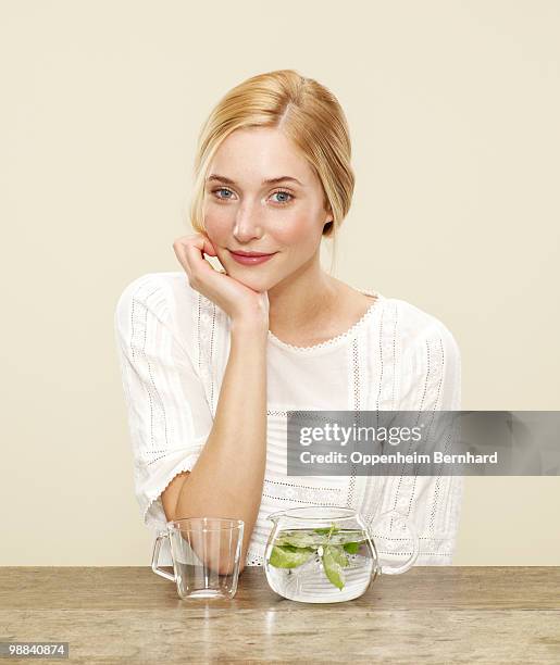 female smiling with fresh brewing tea - mano sul mento foto e immagini stock