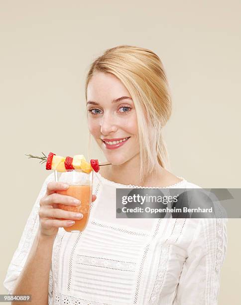 female smiling as she drinks a fruit smoothie - 5 am tag stock-fotos und bilder