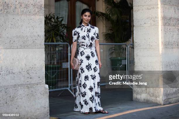 Caroline Issa wears a white dress with a floral print and a cream-colored purse outside the Miu Miu Cruise 2019 show on June 30, 2018 in Paris,...