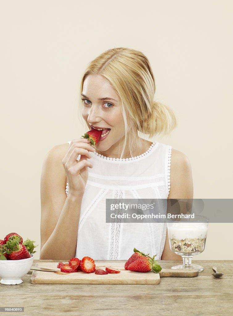 Female eating a fresh strawberry