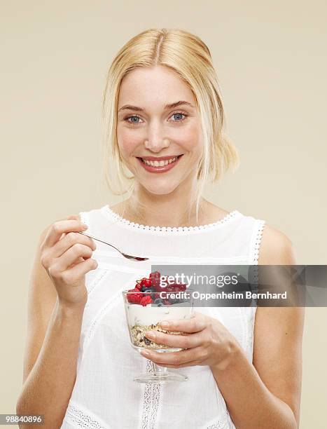 smiling female holding bowl of cereal and berries - bowl of cereal ストックフォトと画像