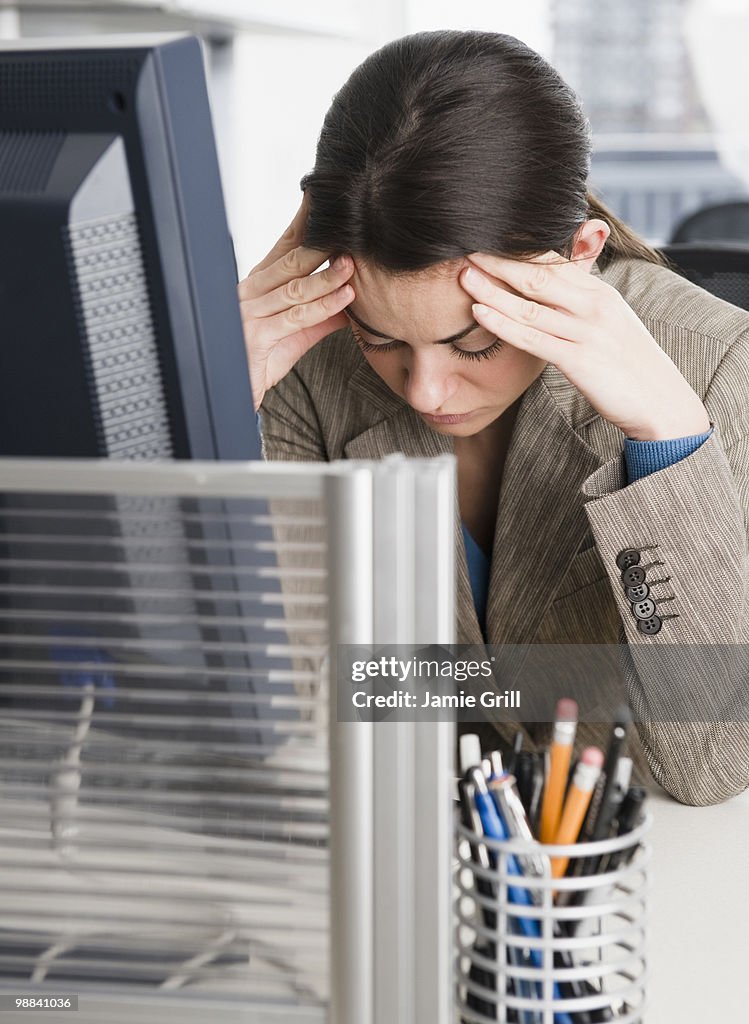 Businesswoman with head in hands at office