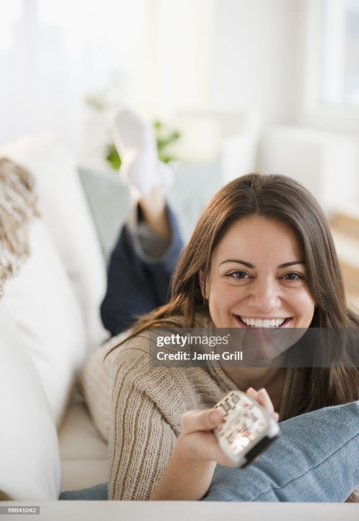 Woman watching television, smiling
