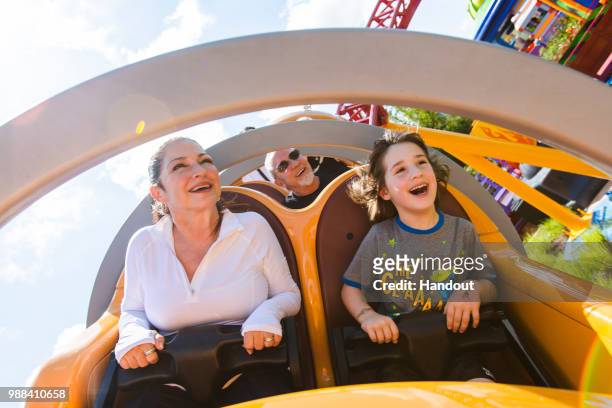 In this handout image provided by Walt Disney World Resort, Gloria Estefan, Emilio Estefan and their grandson, Sasha, enjoy Slinky Dog Dash coaster...