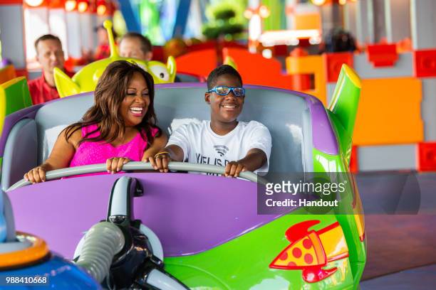 In this handout image provided by Walt Disney World Resort, actress Sherri Shepherd and her son, Jeffrey, take a spin aboard Alien Swirling Saucers...