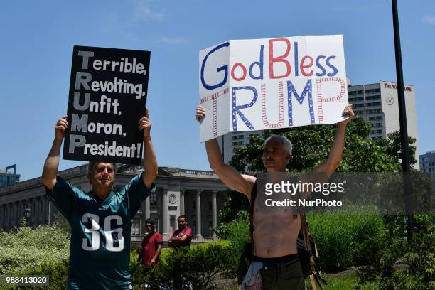 Protestors counter Howard Caplan, a local Trump supporter who holds a sign that reads God Bless Trump, as he stands, surrounded by Police officers,...