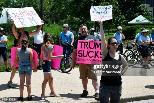 Protestors counter Howard Caplan, a local Trump supporter who holds a sign that reads God Bless Trump, as he stands, surrounded by Police officers,...