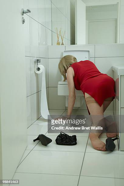 woman with her head over a toilet bowl  - high heels photos stockfoto's en -beelden