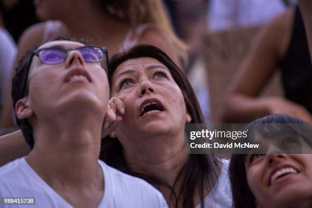 People watch as detainees held inside the Metropolitan Detention Center respond to their calls of encouragement on June 30, 2018 in Los Angeles,...