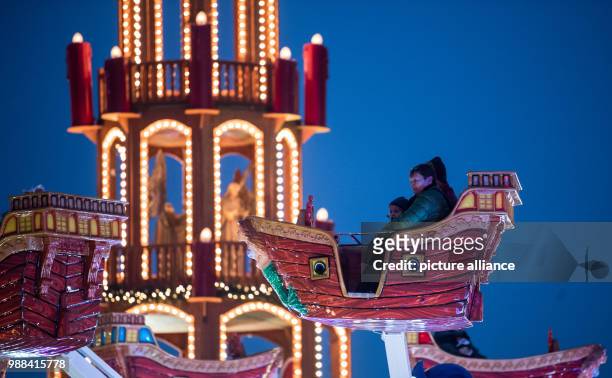 Visitors enjoy a ride on a merry-go-round at the newly opened Christmas market on the Landsberger Allee road in Berlin, Germany, 1 December 2017. The...