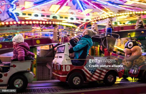 Year old Zoe takes a ride on a merry-go-round at the newly opened Christmas market on the Landsberger Allee road in Berlin, Germany, 1 December 2017....