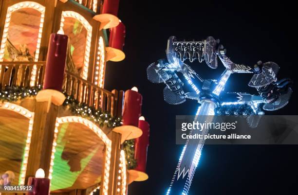 Visitors enjoy a ride on a spinning fairground ride at the newly opened Christmas market on the Landsberger Allee road in Berlin, Germany, 1 December...