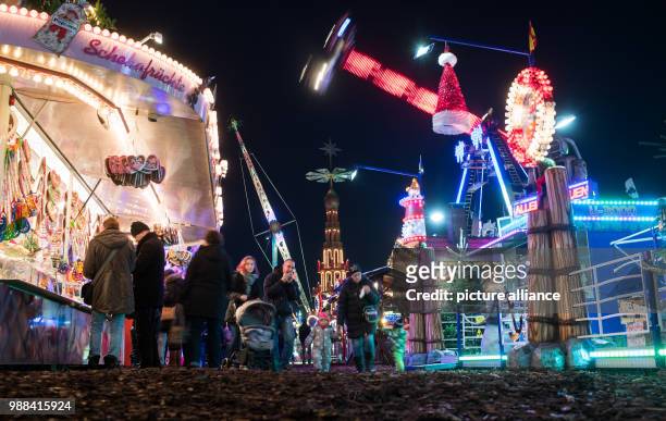 Visitors stroll past festive decorated Christmas stalls and fairground rides at the newly opened Christmas market on the Landsberger Allee road in...