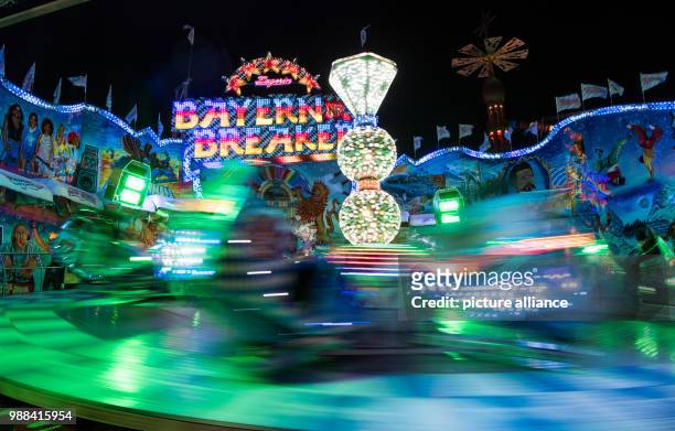 Visitors enjoy a ride on a fast spinning fairground ride at the newly opened Christmas market on the Landsberger Allee road in Berlin, Germany, 1...