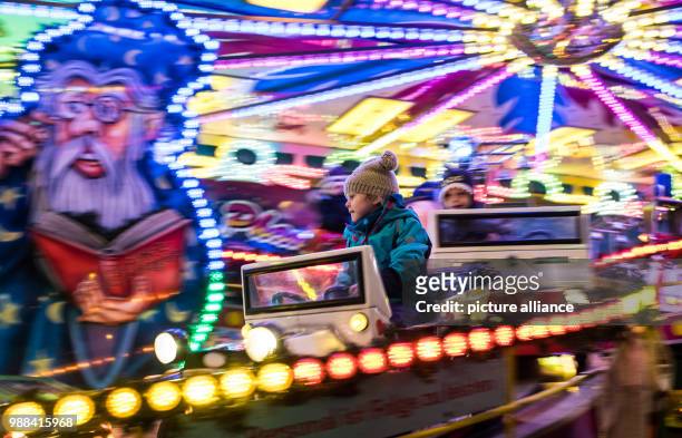 Dpatop - 5-year old Zoe takes a ride on a merry-go-round at the newly opened Christmas market on the Landsberger Allee road in Berlin, Germany, 1...