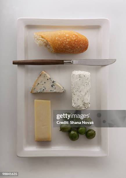 cheese plate with bread, olives, and knife - bread knife stock-fotos und bilder