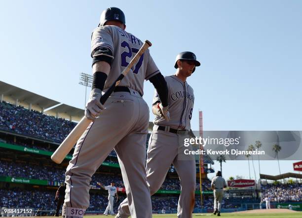 LeMahieu of the Colorado Rockies is congratulated by Trevor Story of the Colorado Rockies after scoring on pass ball from third base during the...