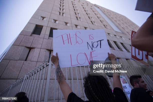 People demonstrate and call out words of encouragement to detainees held inside the Metropolitan Detention Center after marching to decry Trump...