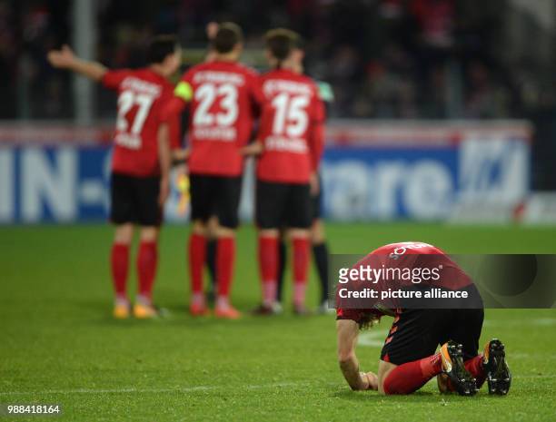 Freiburg's Caglar Soeyuencue kneels on the grass in disappointment after the German Bundesliga soccer match between SC Freiburg and Hamburger SV in...