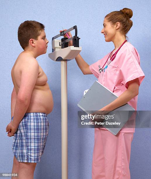 doctor weighing 12 year old over weight boy - avid pro tools stock-fotos und bilder