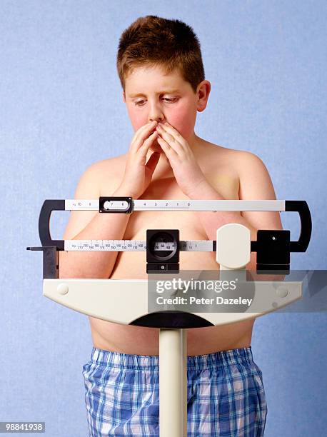 12 year old obese boy weighing himself - chubby boy fotografías e imágenes de stock