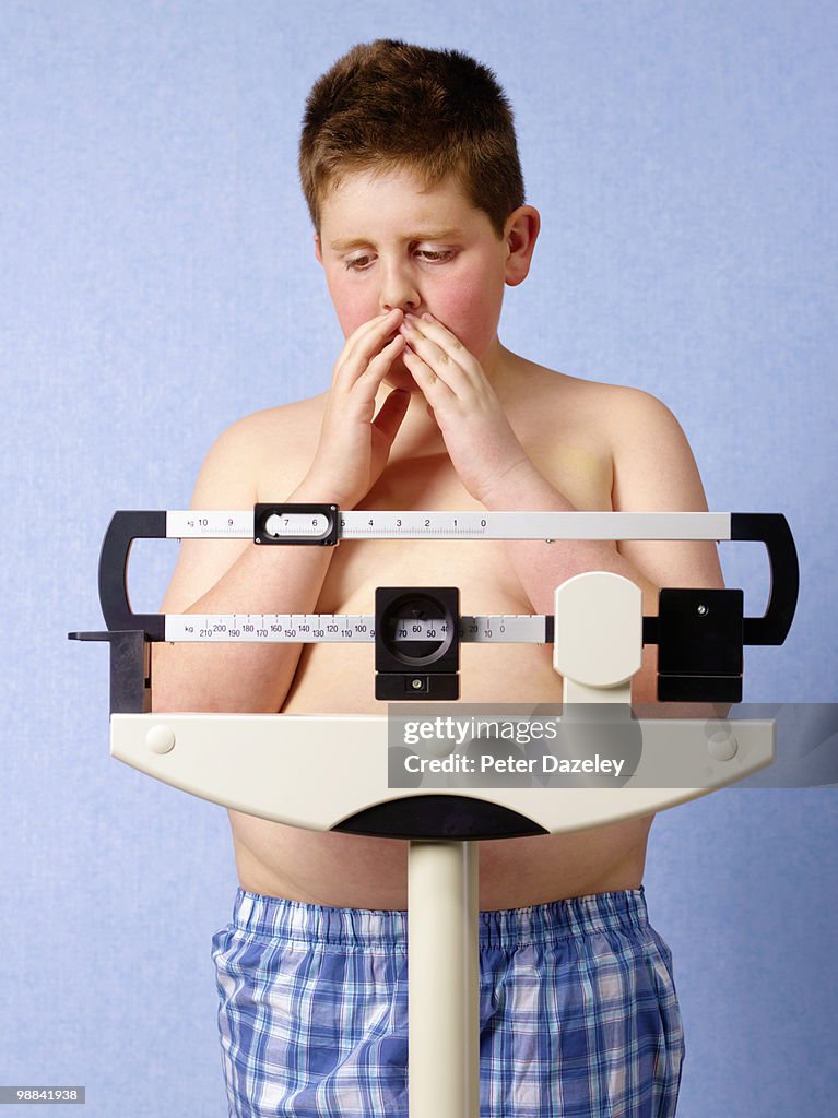 12 year old obese boy weighing himself
