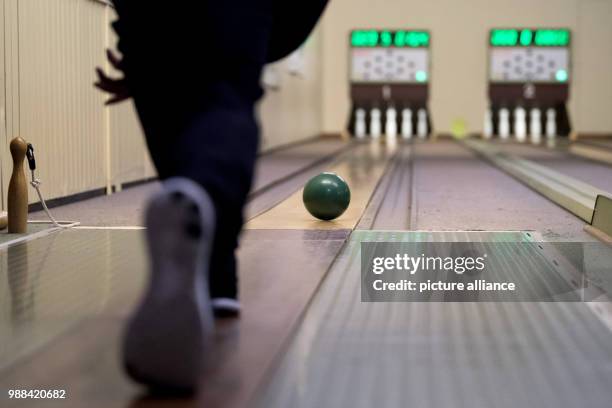 Bowling player takes a turn at hitting the pins of a fully automated bowling alley with a bowling ball at the bowling centre in Bovenden, Germany, 1...