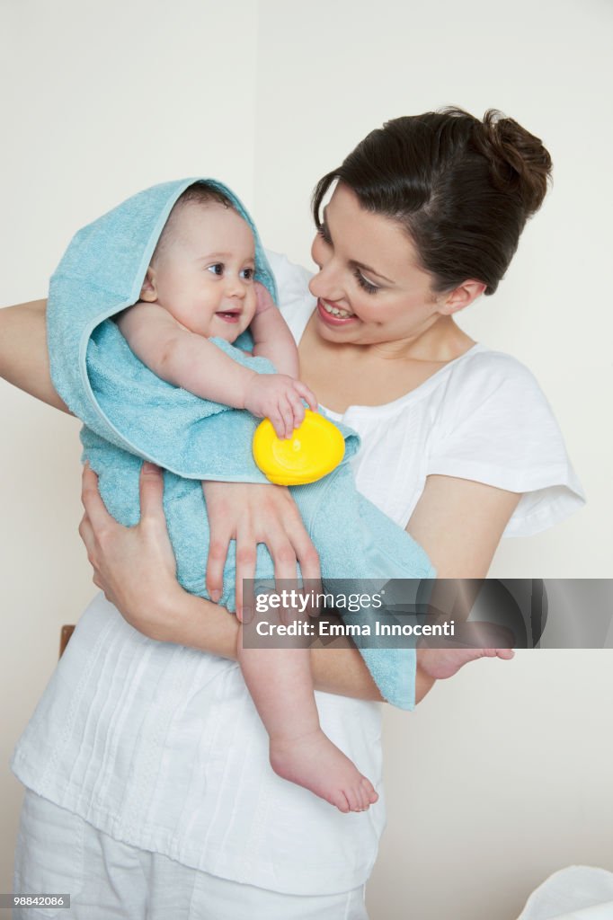 Mum holding baby wrapped in blue towel