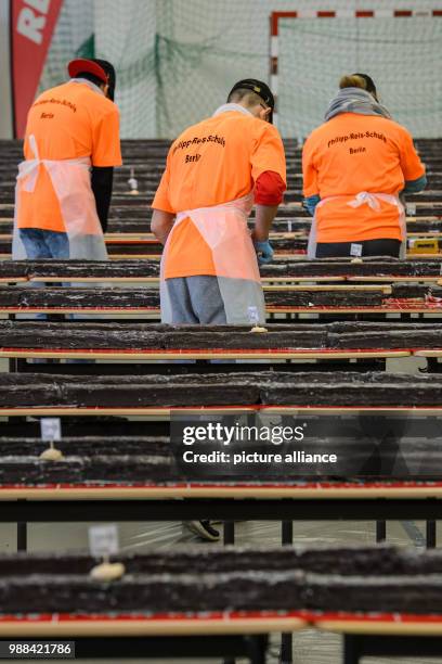 Pupils at the Philipp Reis school cut pieces of the giant "hedgehog slice" in a gymnasium for sale during an attempt at a world record in Berlin,...