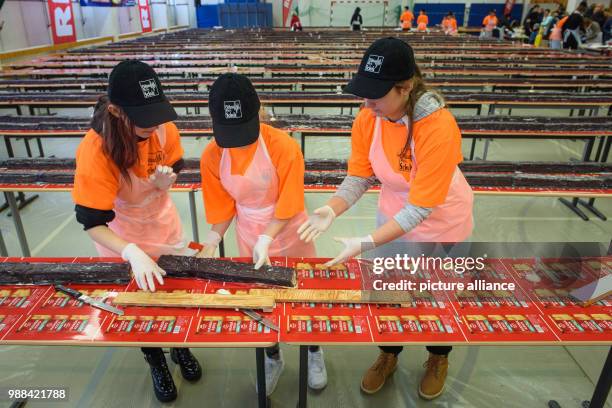 Pupils at the Philipp Reis school cut pieces of the giant "hedgehog slice" in a gymnasium for sale during an attempt at a world record in Berlin,...