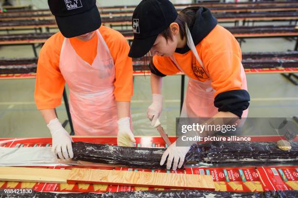 Pupils at the Philipp Reis school cut pieces of the giant "hedgehog slice" in a gymnasium for sale during an attempt at a world record in Berlin,...