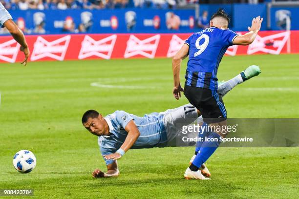 Sporting Kansas City midfielder Roger Espinoza falls after a collision with Montreal Impact midfielder Alejandro Silva during the Sporting Kansas...